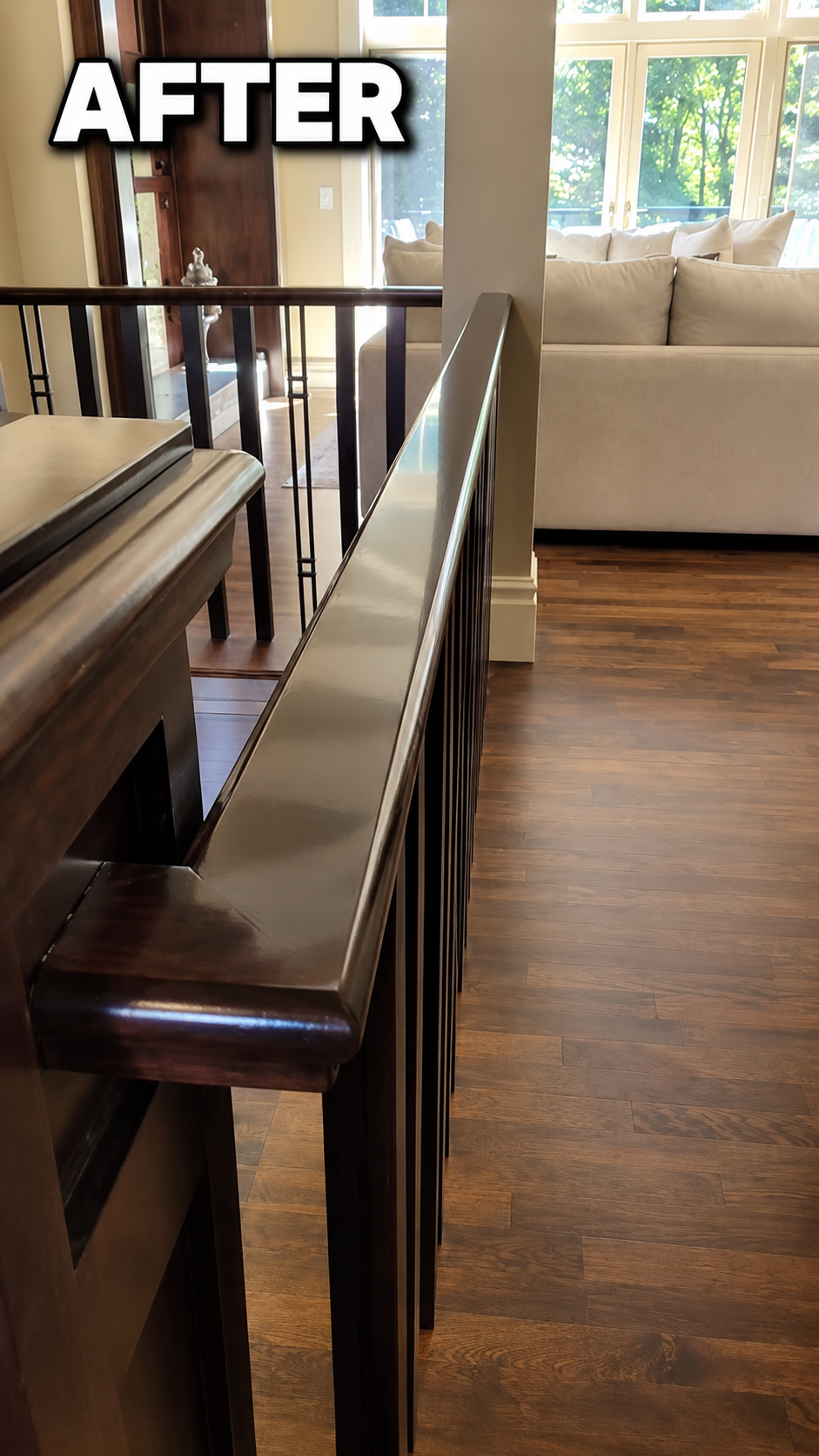 Completed railing with a smooth, reflective dark wood finish beside the living room
